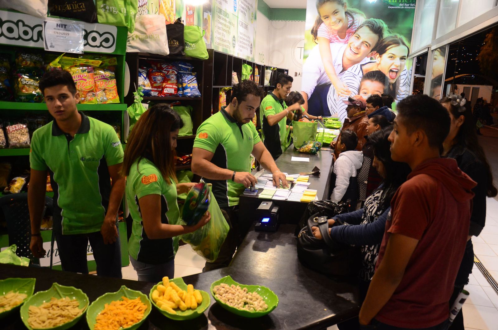 Tienda de marca de Orgánica en una feria, con el equipo en polos verdes