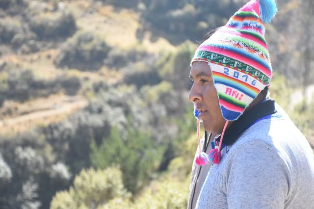 Productor con chullo de colores, de perfil, en la ladera